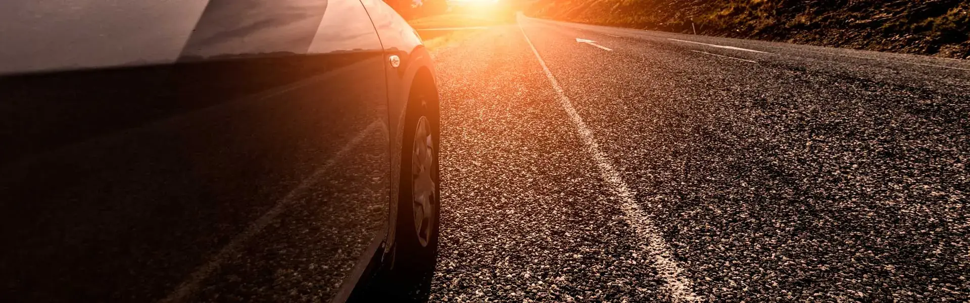 Fahrzeug auf der Landstraße im Gegenlicht – Reifen als einziger Kontakt zur Fahrbahn
